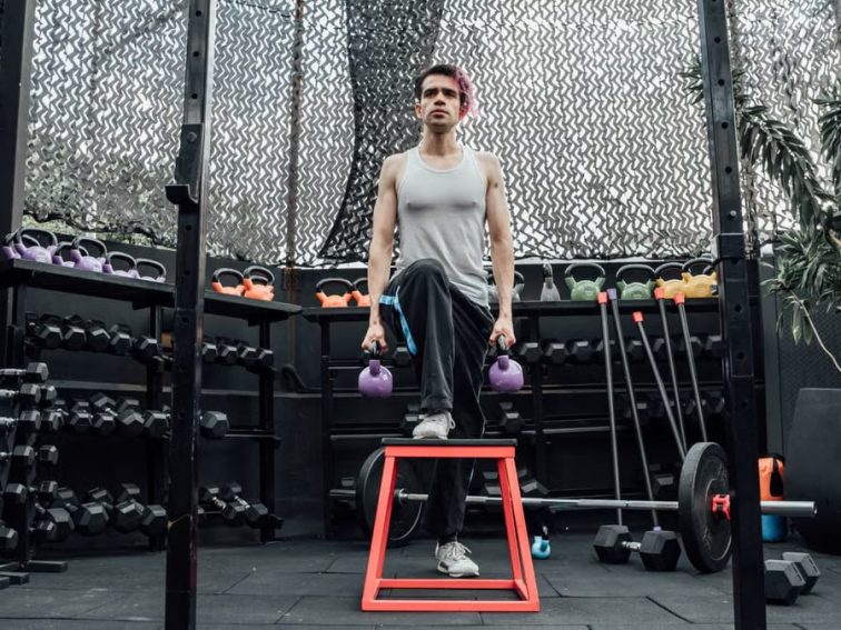 Adult male performing kettlebell exercises in a modern Mexico City gym.