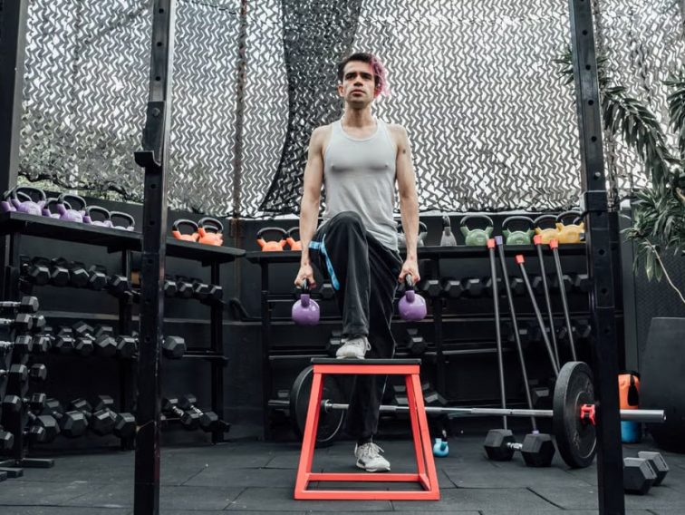 Adult male performing kettlebell exercises in a modern Mexico City gym.